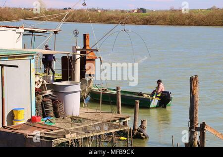 Fishermen on a boat in the region Delta del Po di Veneto. Here an arm of the Po river, Po di Goro, flows into the Adriatic sea. Italy, South Europe. Stock Photo