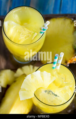 Pineapple juice and fresh ripe pineapple on wooden background Stock Photo
