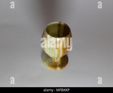 A glass of onyx stone stands on a gray background Stock Photo