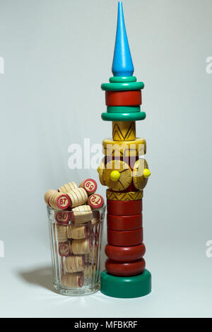 A children's toy in assembled form stands next to a glass filled with barrels from a lotto Stock Photo