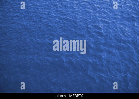 Sea surface aerial view, royal blue background