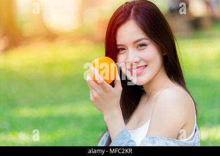 Orange Fruit with Healthy Asian woman for good skin immunity and high vitamin C Stock Photo