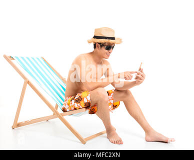Relaxed man sitting in lounger chair and using the phone Stock Photo