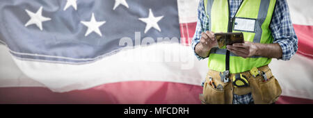 Composite image of mid-section of construction worker using tablet Stock Photo