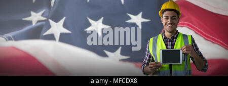 Composite image of happy construction worker holding tablet Stock Photo