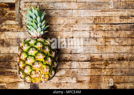 Pineapples on rustic wooden background. Healthy food Stock Photo