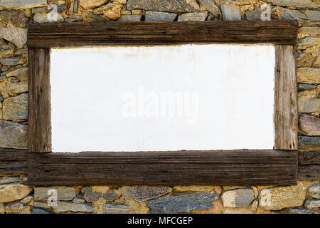 Blank white chalkboard in wooden frame on stone wall Stock Photo