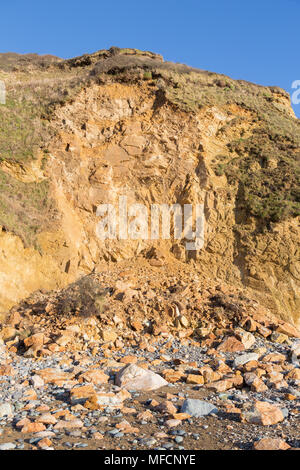 Huge pile of rock fallen from a cliff due to coastal erosion Stock Photo