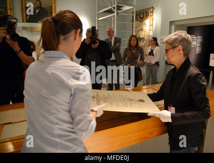 25 April 2018, Germany, Trier: Curator Barbara Wagner (R) and restorator Sarah Bruch place the doctoral certificate of Karl Marx on the exhibition table at the large Karl Marx exhibition at the Rheinische Landesmuseum Trier. According to its organizers, Rhineland-Palatinate's state exhibition 'Karl Marx 1818 - 1883. Life. Work. Times' is the first ever historico-cultural exhibition on the thinker. It can be seen at the Rheinische Landesmuseum Trier and at the Simeonstift Trier city museum. Photo: Harald Tittel/dpa Stock Photo