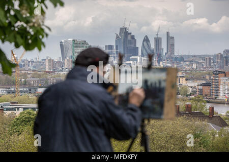 London, UK. 25th April, 2018. UK Weather: A fine artist paints the city landscape including the Gherkin and Cheesegrater buildings from Greenwich Park on a cloudy afternoon. Credit: Guy Corbishley/Alamy Live News Stock Photo