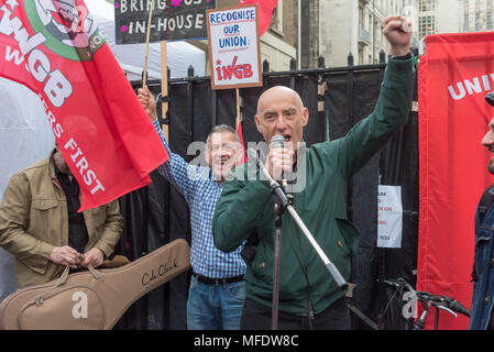 London, UK. 25th April 2018.Grim Chip of Poetry on the Picket Line raises his fist before he performs at the rally by workers, students and other trade unionists supporting over 100 cleaners, porters, security officers, receptionists, gardeners, post room staff and audiovisual staff in the Independent Workers Union of Great Britain - IWGB at the end of the first day of a two day strike at the University of London central administration. The workers, employed by various outsourcing companies are demanding to be directly employed by the University, and receive the same conditions and benefits as Stock Photo