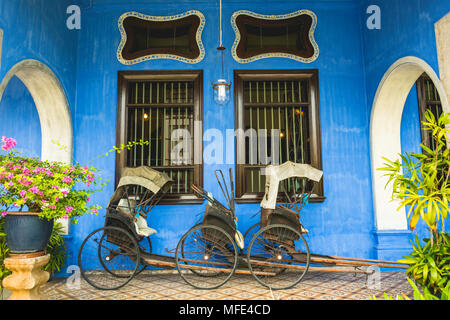 Old rickshaws on the blue wall, Cheong Fatt Tze Mansion, blue villa, Leith Street in George Town, Penang, Malaysia Stock Photo