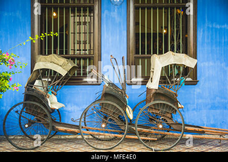 Old rickshaws on the blue wall, Cheong Fatt Tze Mansion, blue villa, Leith Street in George Town, Penang, Malaysia Stock Photo