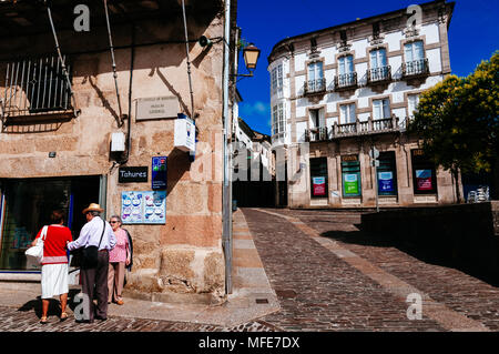 Old people talking standing on cobbled street next to typical houses. Mondoñedo, Lugo, Galicia, Spain. Stock Photo