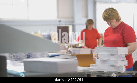 Female workers sorting a paper stacks in the typography Stock Photo