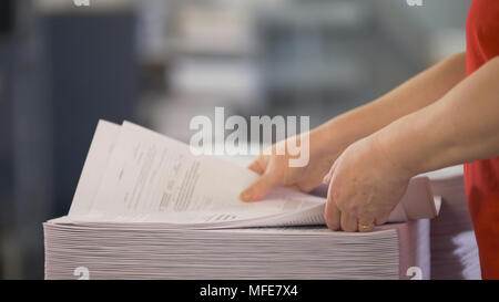 Female hands sorts the stacks of newspapers in typography Stock Photo