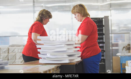 Female workers sorting a paper stacks in the typography Stock Photo