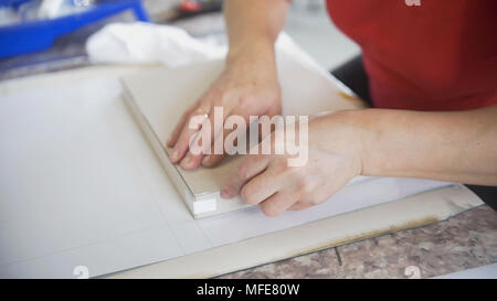 Hands of female worker packing paper in the typography Stock Photo