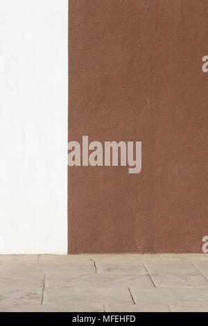 White and brown plastered wall and pavement as background Stock Photo