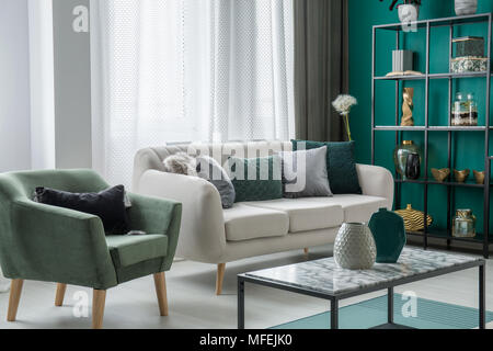 Green and silver decorative pillows placed on a light grey couch