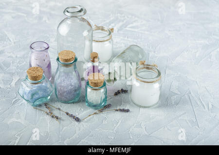 Glass bottles and jars with aromatic oils and salt and on a light background Stock Photo
