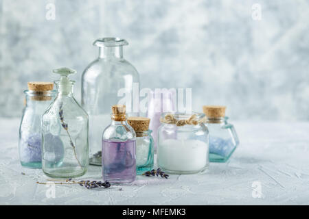 Glass bottles and jars with aromatic oils and salt and on a light background Stock Photo