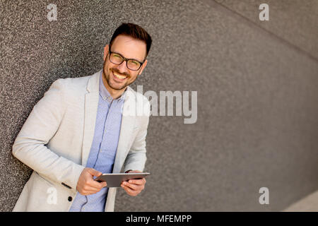 Portrait of a young businessman holding digital tablet outdoor in urban enviroment Stock Photo
