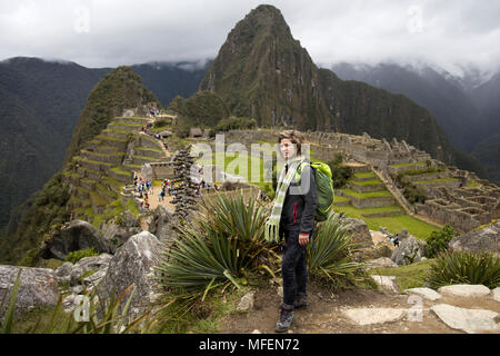 Young woman standing above Machu Picchu Inca citadel in Peru Stock Photo