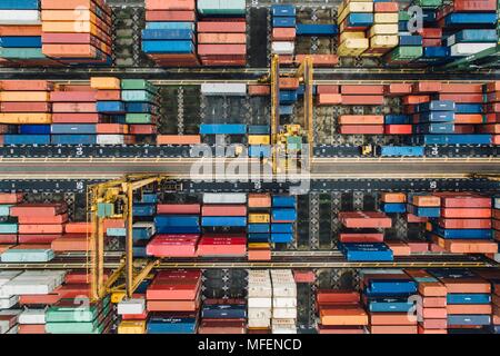 sea containers does not contain visible brand names or logos. Industrial port crane loading import and export Containers box in a Cargo container ship Stock Photo