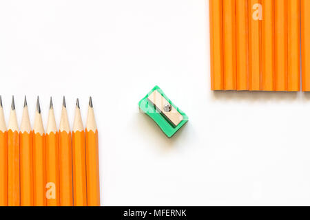 Few yellow wooden pencils lying in a row and sharpener on white background Stock Photo