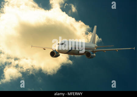 Passenger airplane on background with dark sunset sky and clouds Stock Photo