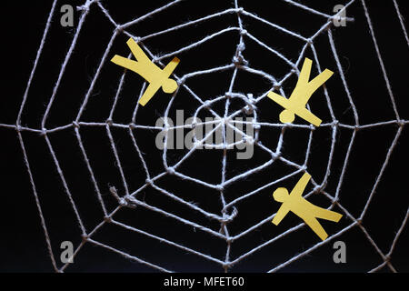 Conceptual background with web made from rope and yellow paper men on dark Stock Photo