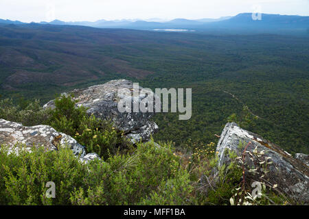 Three stones in front of view into the valley with blue mountains at Reeds Lookout, Grampians, Victoria, Australia Stock Photo
