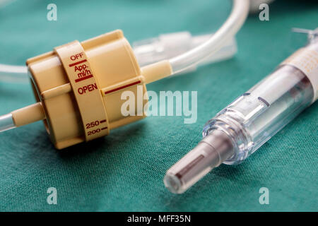 Dial flow next to a syringe at a hospital table, conceptual image Stock Photo