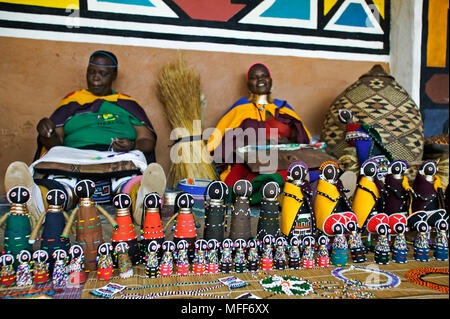 NDEBELE WOMEN make colourful dolls in the style of  traditional Ndebele costumes Lesedi Cultural Village, Johannesburg  South Africa Stock Photo