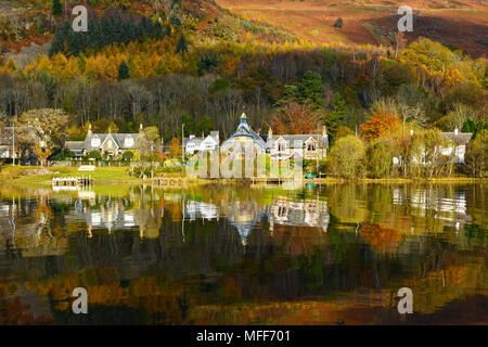 Looking across Loch Earn to St Fillans village, Scotland UK  Autumn colours and reflections clear blue sky sunny day October 2017 Stock Photo