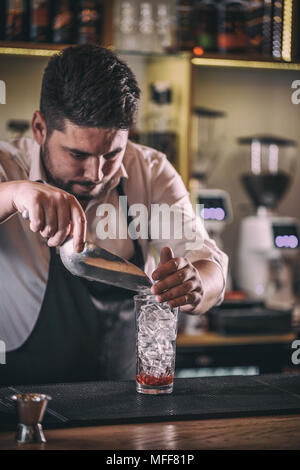 Bartender putting broken ice in a glass Stock Photo