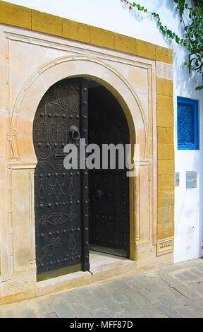 black wooden door of an Arabian house with a pattern in Tunisia. Stock Photo