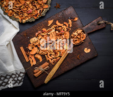 Dried pieces of apples in an iron plate and on a brown wooden board, top view Stock Photo