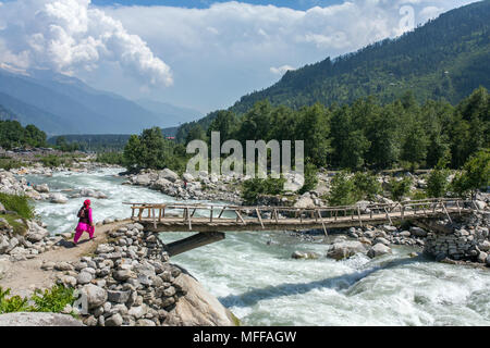 Manali, India - May 27, 2017: Unidentified indian woman walk on the wooden bridge near Vashisht village in Kullu valley, Himachal Pradesh, India Stock Photo