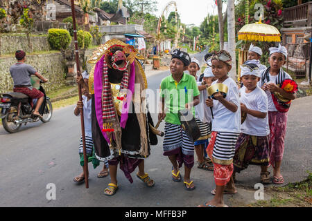 Bali, Indonesia - September 7, 2016: Balinese kids playing Barong walking on the streets of Ubud in Bali, Indonesia. Stock Photo