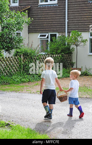 Two small boys carrying a basket of eggs. Stock Photo