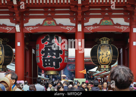 A huge red chochin or paper lantern hangs on the Hozomon Gate of the Sensoji Temple complex in Tokyo, Japan, with two copper toro on either side. Stock Photo