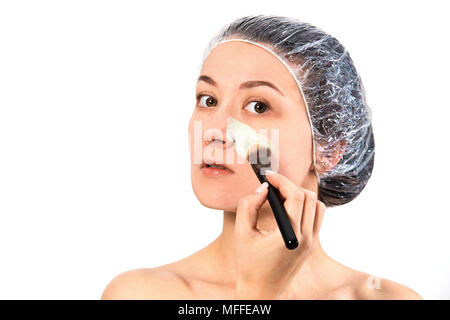 Skin care concept. Woman applying cleansing mask on face skin isolated on wgite background. Stock Photo
