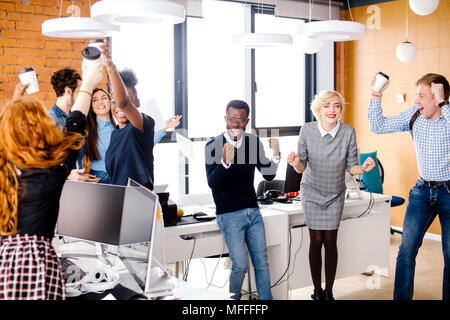 mixed-race office workers are happy because of the winning of their favourite hockey team. football, hockey fan. Stock Photo