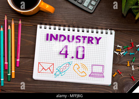 Notebook with a notes INDUSTRY 4.0 on the office table with tools. Concept with elements of infographics. Stock Photo