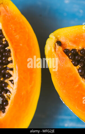 Close up of tropical fruit papaya cut i half on a wooden background Stock Photo