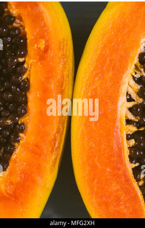 Close up of tropical fruit papaya cut i half on a wooden background Stock Photo