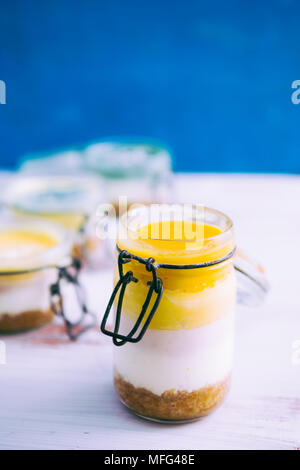 Cheesecake on a glass jar, made with different colorful layer, mango, mango cheese, acai cheese, yogurt and crusty brownie. Stock Photo