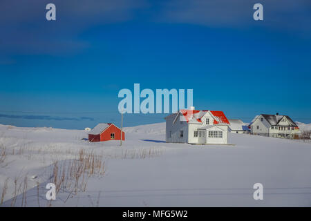 SVOLVAER, LOFOTEN ISLANDS, NORWAY - APRIL 10, 2018: Outdoor view of wooden houses partial covered with snow in Lofoten islands Stock Photo